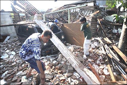 2006년 5월 28일, 인도네시아 반툴 주민들이 지진으로 폐허가 된 집터에서 성한 가구들을 찾고 있는 모습.